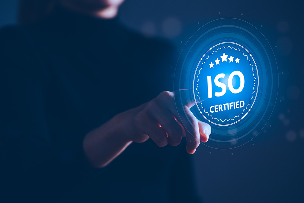 Henkilö osoittaa ISO-sertifikaatilogoa sormellaan.
